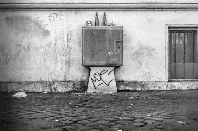 Photograph of A Random Roman Ledge with Two Empty Beer Bottles Atop